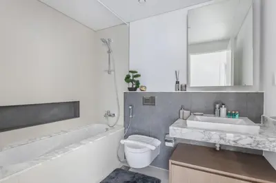 a bathroom with a toilet and a tub and a sink at Frank Porter - The Grand in Dubai