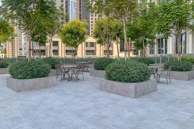 a patio with tables and chairs in front of a building at Frank Porter - The Grand in Dubai