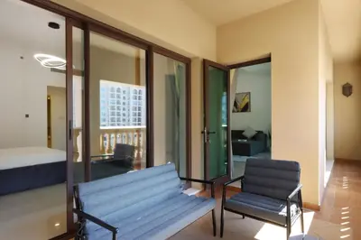 a living room with a bench and a bedroom at 1BR in Palm Jumeirah, Walk to the Beach and Mall in Dubai
