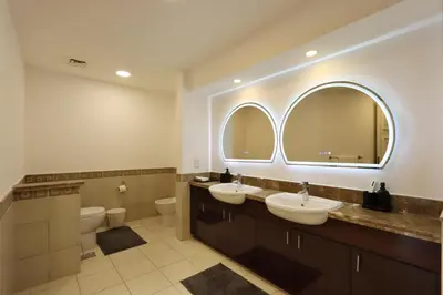 a bathroom with two sinks and two mirrors at 1BR in Palm Jumeirah, Walk to the Beach and Mall in Dubai