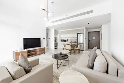 a living room with a couch and a tv at Silkhaus Marina View with Tower's Private Beach in Dubai