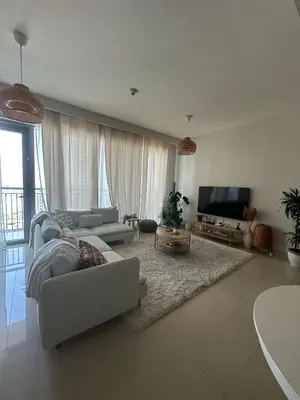 a living room with a white couch and a television at Beautiful Flat in Harbor Views in Dubai