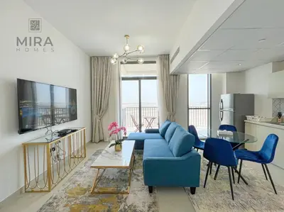 a living room with a blue couch and a table at Mira Holiday Homes - Serviced 1 bedroom in Midtown in Dubai