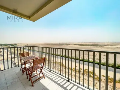 a balcony with a table and chairs looking out over the desert at Mira Holiday Homes - Serviced 1 bedroom in Midtown in Dubai