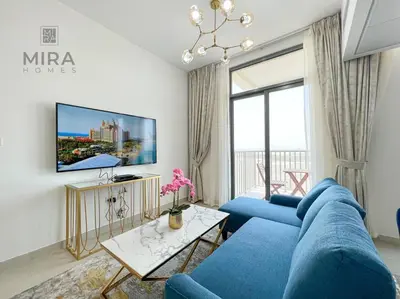 a living room with a blue couch and a tv at Mira Holiday Homes - Serviced 1 bedroom in Midtown in Dubai