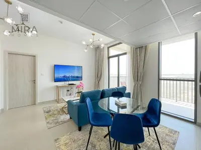 a living room with blue chairs and a glass table at Mira Holiday Homes - Serviced 1 bedroom in Midtown in Dubai