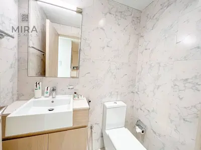 a white bathroom with a sink and a toilet at Mira Holiday Homes - Serviced 1 bedroom in Midtown in Dubai