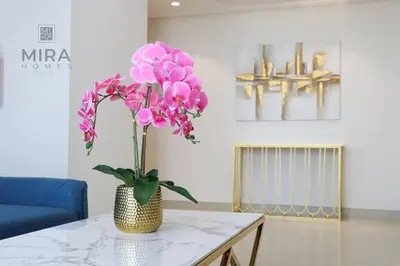 a vase with pink flowers sitting on a table at Mira Holiday Homes - Serviced 1 bedroom in Midtown in Dubai
