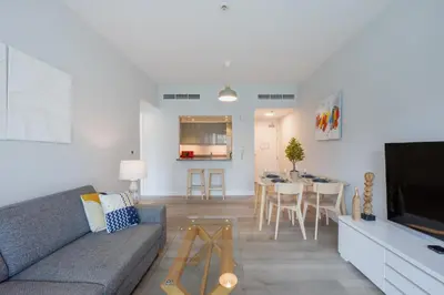 a living room with a couch and a dining room at The Point Tower - Chic One Bedroom in Dubai
