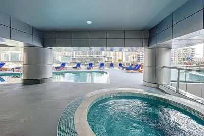 a large swimming pool in a building with a view at The Point Tower - Chic One Bedroom in Dubai