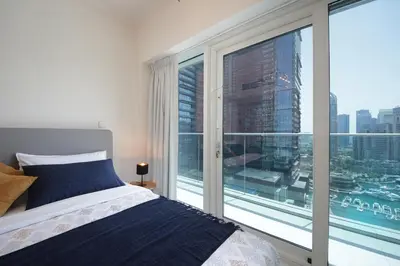 a bedroom with a bed and a large window at AHH - Panoramic Marina Views - Stylish 2BR at DAMAC Heights in Dubai