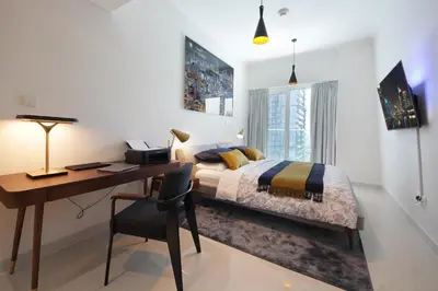 a bedroom with a desk and a bed and a desk and chair at AHH - Panoramic Marina Views - Stylish 2BR at DAMAC Heights in Dubai