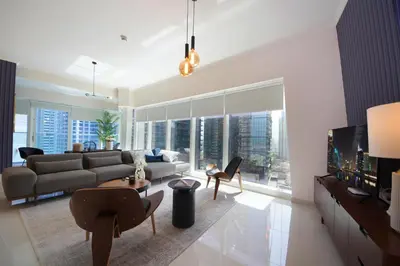 a living room with a couch and a tv at AHH - Panoramic Marina Views - Stylish 2BR at DAMAC Heights in Dubai