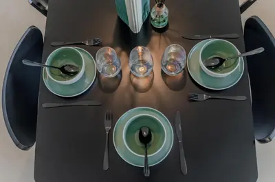 a table with green plates and silverware on it at Clever Guest Concorde JLT in Dubai