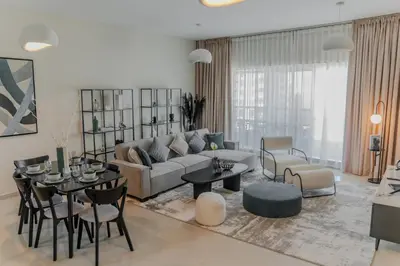 a living room with a couch and tables and chairs at Clever Guest Concorde JLT in Dubai