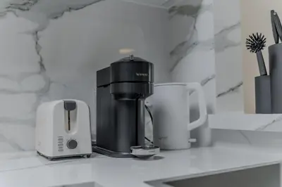 a coffee maker and two cups on a counter at Clever Guest Concorde JLT in Dubai