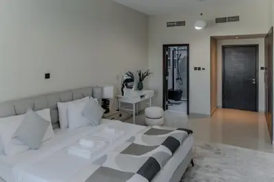 a bedroom with a large white bed and a desk at Clever Guest Concorde JLT in Dubai