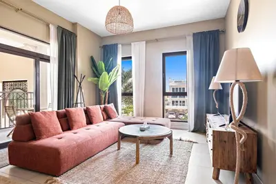 a living room with a pink couch and a table at StoneTree - Cozy 1 BR near Madinat Jumeirah and Burj Al Arab in Dubai