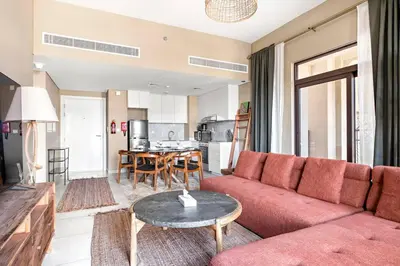 a living room with a red couch and a table at StoneTree - Cozy 1 BR near Madinat Jumeirah and Burj Al Arab in Dubai