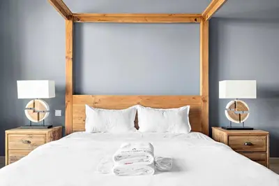 a bed with two lamps and towels on it at StoneTree - Cozy 1 BR near Madinat Jumeirah and Burj Al Arab in Dubai