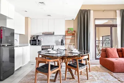 a kitchen with a table and chairs in a room at StoneTree - Cozy 1 BR near Madinat Jumeirah and Burj Al Arab in Dubai