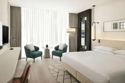 a hotel room with a bed and two chairs at Sheraton Grand Hotel, Dubai in Dubai