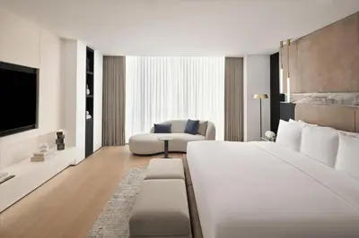 a hotel room with a large bed and a chair at Sheraton Grand Hotel, Dubai in Dubai