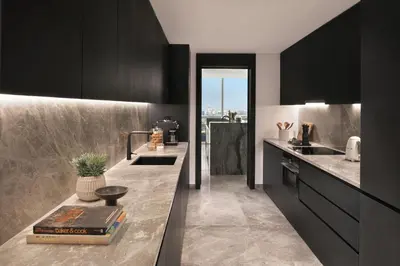 a kitchen with black cabinets and a counter with a book at Sheraton Grand Hotel, Dubai in Dubai