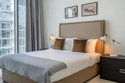 a bedroom with a bed and a large window at Residence 12 I District One I 1 Bedroom Apartment in Dubai