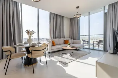 a living room with a couch and a table at Residence 12 I District One I 1 Bedroom Apartment in Dubai