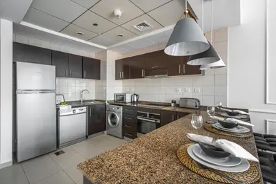 a kitchen with stainless steel appliances and a counter top at GuestReady - Comfort Stay l Close To Marina Mall in Dubai
