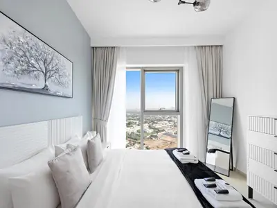 a white bedroom with a large bed with a window at Brand New Elegant 1BDR Direct Access to Dubai Mall in Dubai