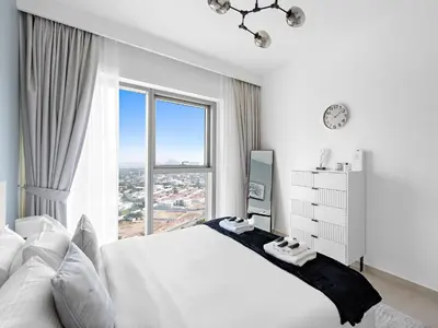 a bedroom with a white bed with a large window at Brand New Elegant 1BDR Direct Access to Dubai Mall in Dubai