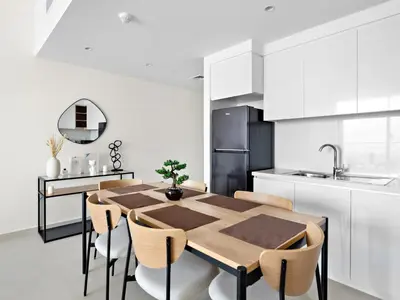 a kitchen and dining room with a wooden table and chairs at Brand New Elegant 1BDR Direct Access to Dubai Mall in Dubai