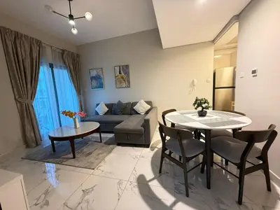 a living room with a table and a couch at StoneTree - Cozy and Modern 1 BR in Dubai