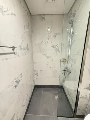 a bathroom with a shower with a glass door at StoneTree - Cozy and Modern 1 BR in Dubai