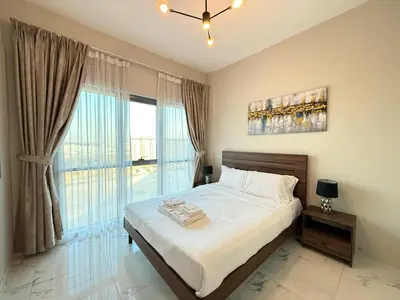 a bedroom with a bed and a large window at StoneTree - Cozy and Modern 1 BR in Dubai