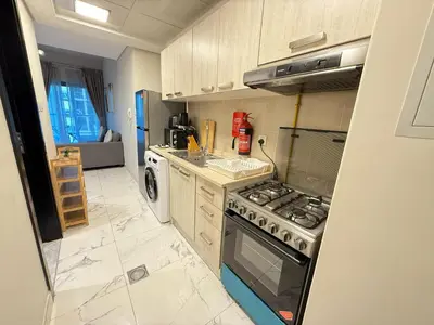 a kitchen with a stove and a sink at StoneTree - Cozy and Modern 1 BR in Dubai