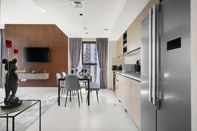 a kitchen and dining room with a table and a refrigerator at Sky High Gem in Central Dubai with Burj Khalifa and Fountain Views in Dubai