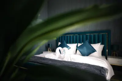 two swans sitting on a bed with blue pillows at Sky High Gem in Central Dubai with Burj Khalifa and Fountain Views in Dubai