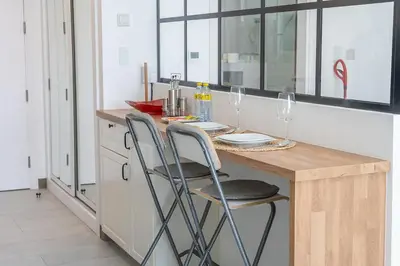 a kitchen with a counter with two chairs at a table at Luxury & Stylish Studio - JVC in Dubai