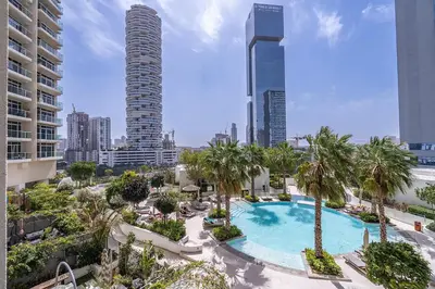 an aerial view of a pool with palm trees and buildings at Luxury & Stylish Studio - JVC in Dubai