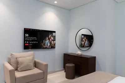 a bedroom with a bed and a mirror and a chair at Burj Khalifa Views 2BR with Infinity Pool Downtown in Dubai