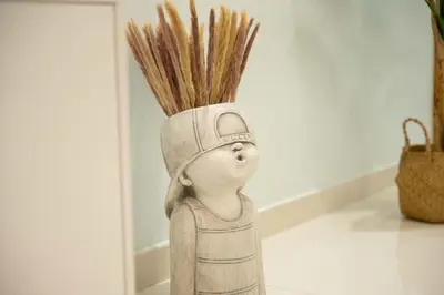 a statue of a person with a hat with some grass at Burj Khalifa Views 2BR with Infinity Pool Downtown in Dubai
