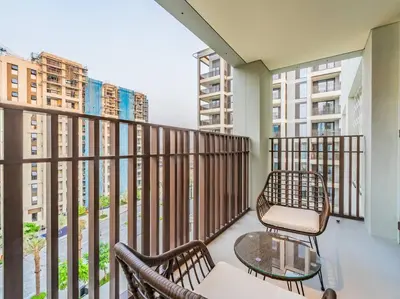 a balcony with two chairs and a table at Coastal Charm Casita : 1BR Creek Beach Elegance in Dubai