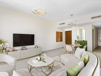 a living room with a white couch and a tv at Sophisticated and Trendy 2BDR In Forte Downtown in Dubai