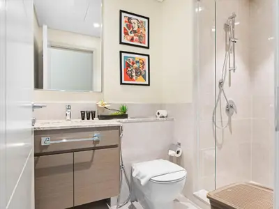 a bathroom with a toilet and a glass shower at Sophisticated and Trendy 2BDR In Forte Downtown in Dubai
