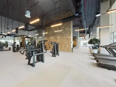 a gym with rows of treadmills and benches at Sophisticated and Trendy 2BDR In Forte Downtown in Dubai