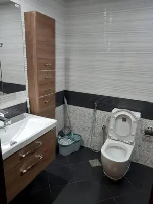 a bathroom with a toilet and a sink and a mirror at StoneTree - Comfortable Studio in Arjan in Dubai