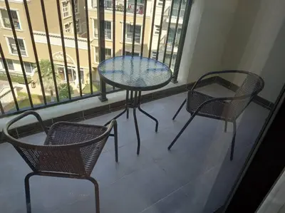 a table and two chairs on a balcony with a window at StoneTree - Comfortable Studio in Arjan in Dubai